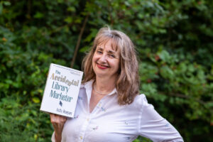 Kathy Dempsey holding her book The Accidental Library Marketer